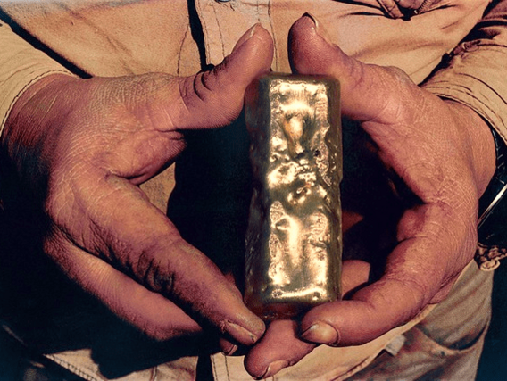 Gold bars Um homem segura uma barra de ouro